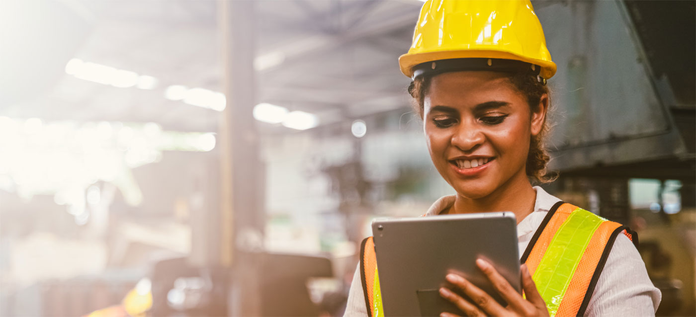 women in construction hat consulting a tablet