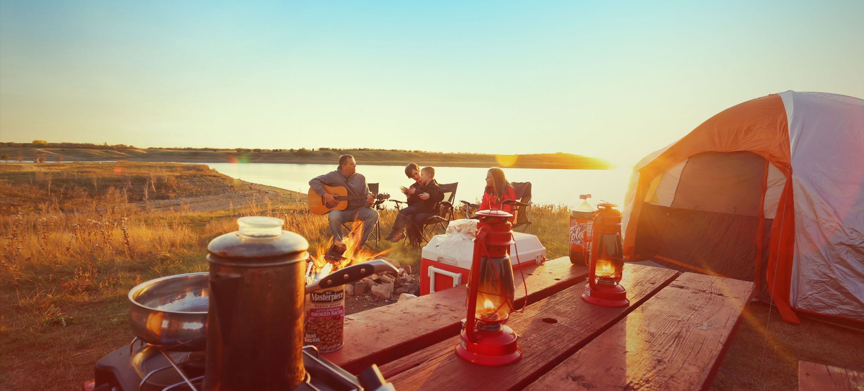 一家人在湖边露营，一起演奏音乐