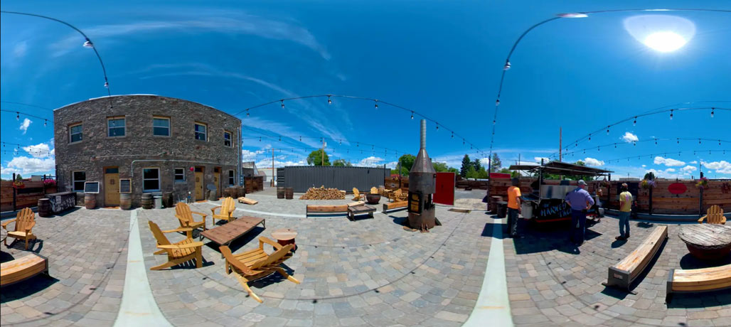 Sunny stone-paved patio with wooden seating