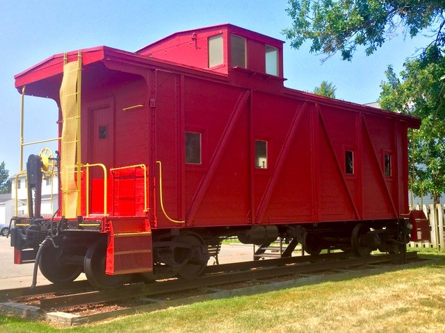 A restored caboose sits at the trailhead in Baxter.