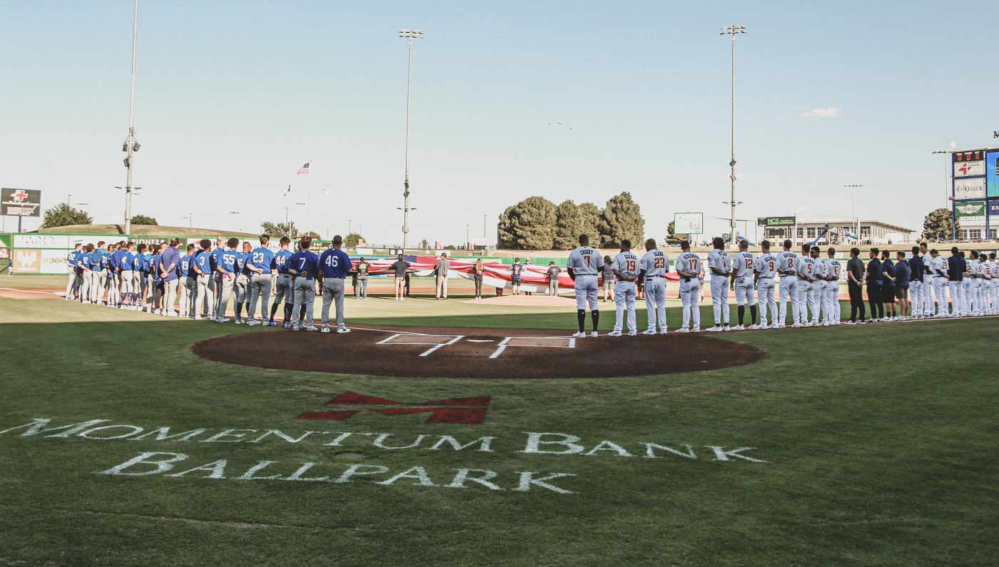 teams standing for the national anthem before a ball game in Midland, TX