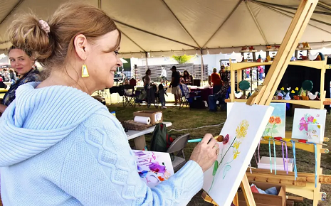 This image shows an artist painting at an easel at the Bastrop Art Fest, set for Nov. 7.