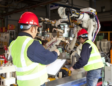 workers tending manufacturing equipment