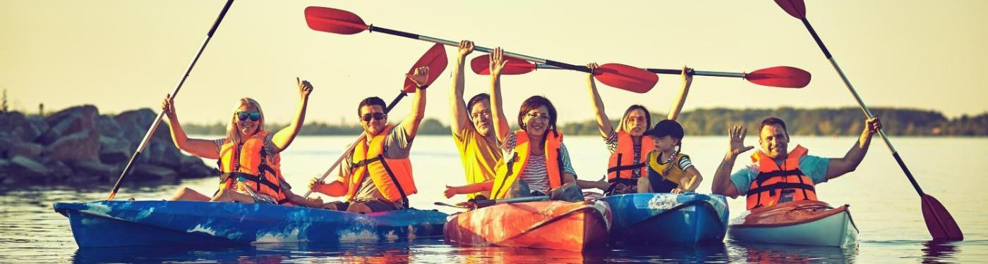 four kayaks, seven individuals paddling on water