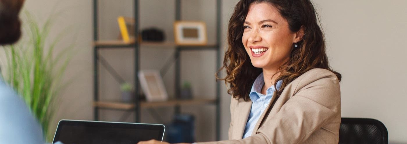 smiling woman shaking hands with a business associate