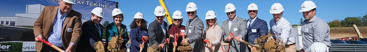 ground breaking ceremony with people in hardhats tossing dirt off their shovel