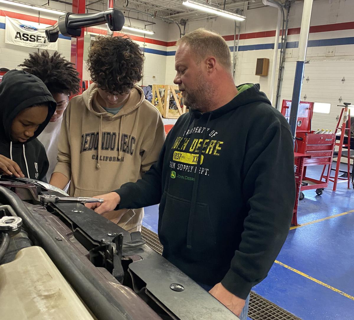 Beloit Memorial High School automotive teacher Guy Olson gives a lesson to Bryan Zuniga, Shy'terra McKinney and Rodrigo Delgado during an Introduction to Automotive class at the Eclipse Center Oct. 18. The automotive classes, which are all taught at the E