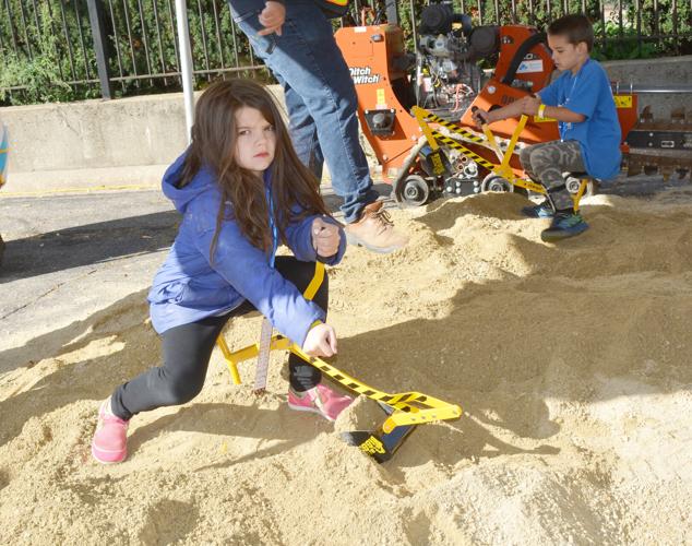 Elena and Micah Norris dig into the sand at an excavation demonstration area at the Community Construction Zone event in Beloit on Saturday. Children and families could get an up-close look at construction equipment and learn about construction-related jo