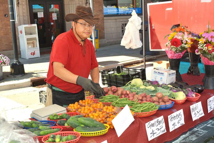 Saona Thao of Cottage Grove arranges his beans, potatoes and other produce at his booth at the Downtown Beloit Farmers Market. The outdoor farmers market is held each Saturday from May through October. Clint Wolf/Beloit Daily News
