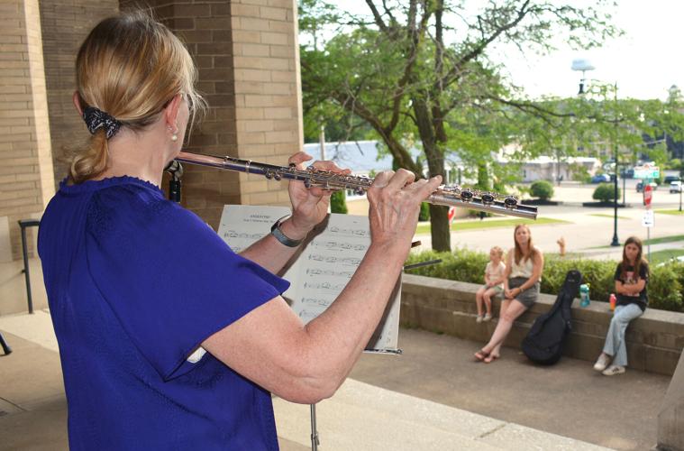 Peggy Rapp plays the flute for those gathered outside the Castle in Beloit Friday afternoon. She was one of many musicians who performed for free during Make Music Day in Beloit. Clint Wolf/Beloit Daily News