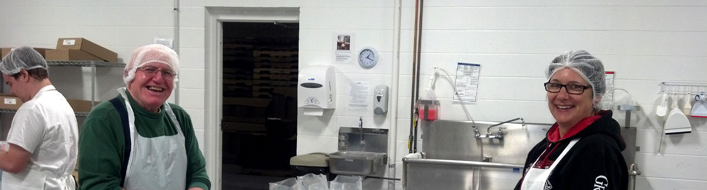 two smiling workers with hairnets on