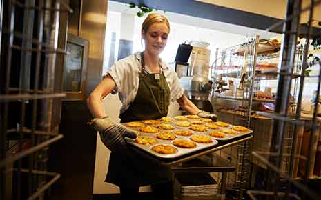 woman with a tray of baked goods