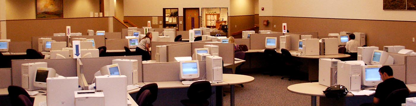 large office room with many computers and people working