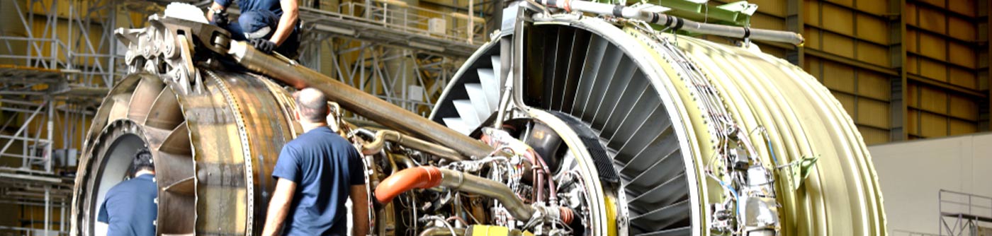 workers building jet engine
