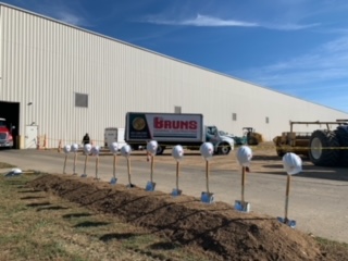 brums industry building, golden shovels in a row with white hard hats on top