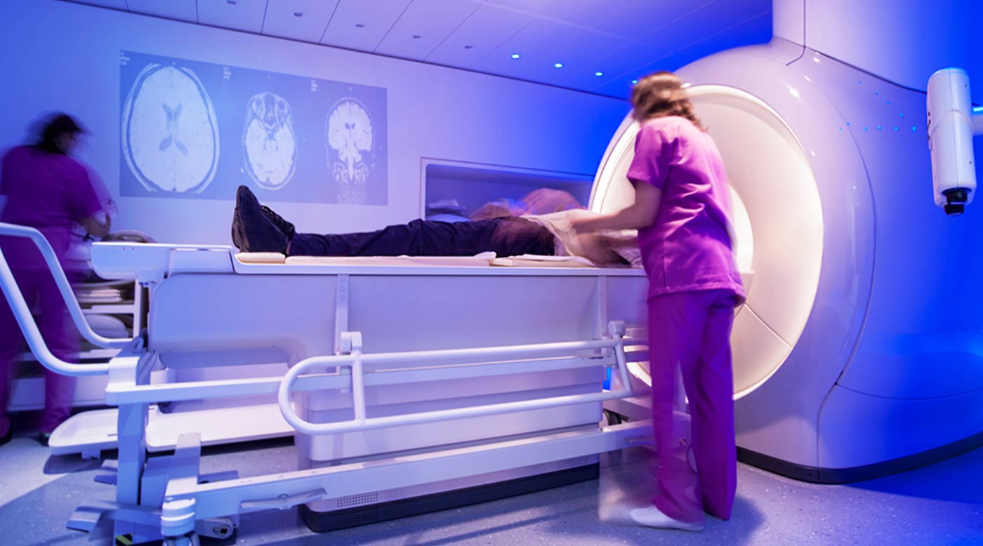 mri machine, patient on table and technician
