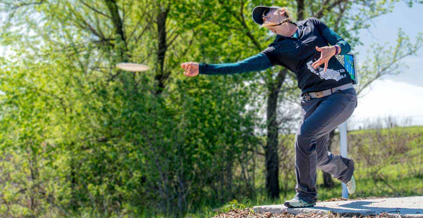 woman tossing a disc off a tee