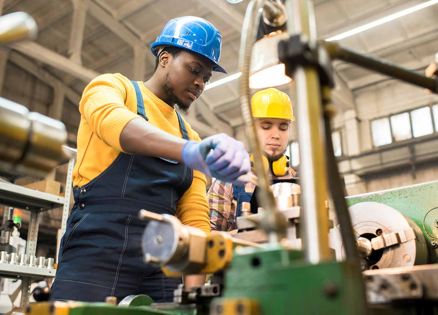 two factory workers working on a machine