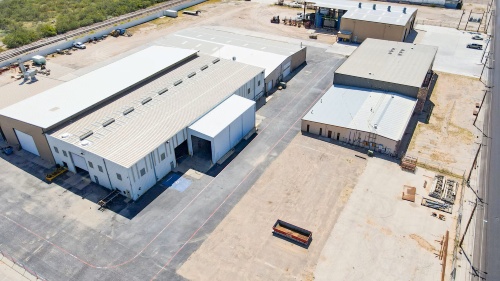 aerial view of large building on the left with two smaller buildings on the right