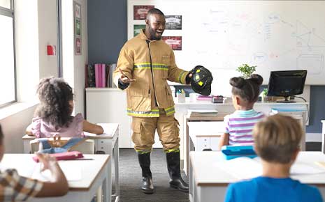 fire fighter talking to elementary kids