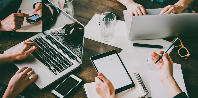 colleagues working around a table with devices