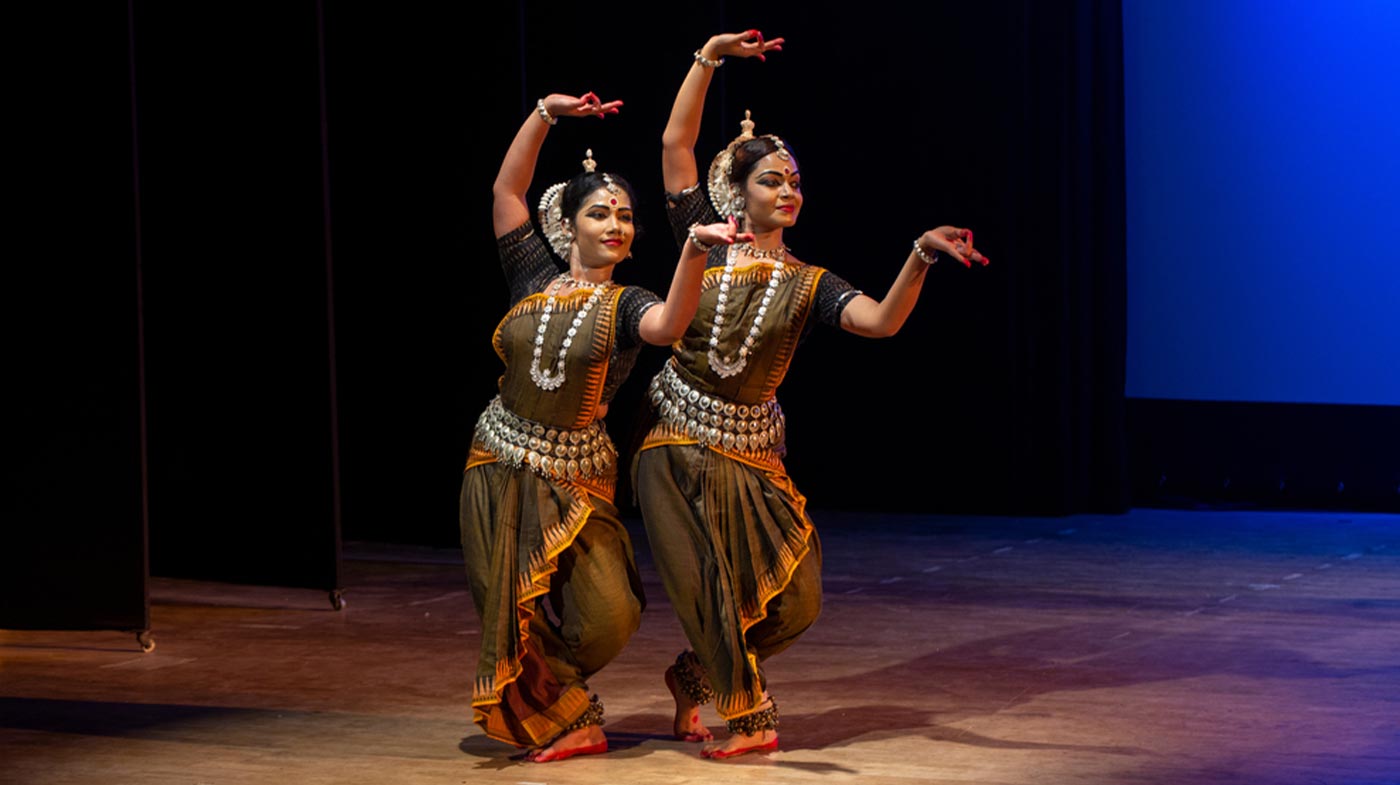 Two Indian classical odissi dancers performing at stage.