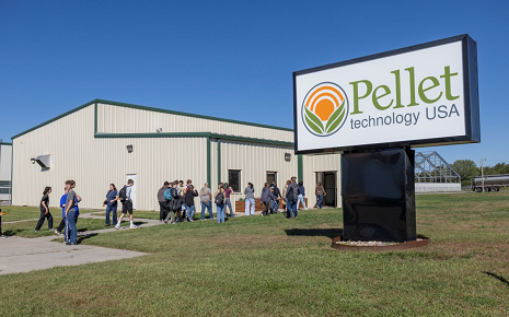 The image shows a group of students touring the Pellet Technology USA (PTUSA York) manufacturing facility in York, Nebraska.