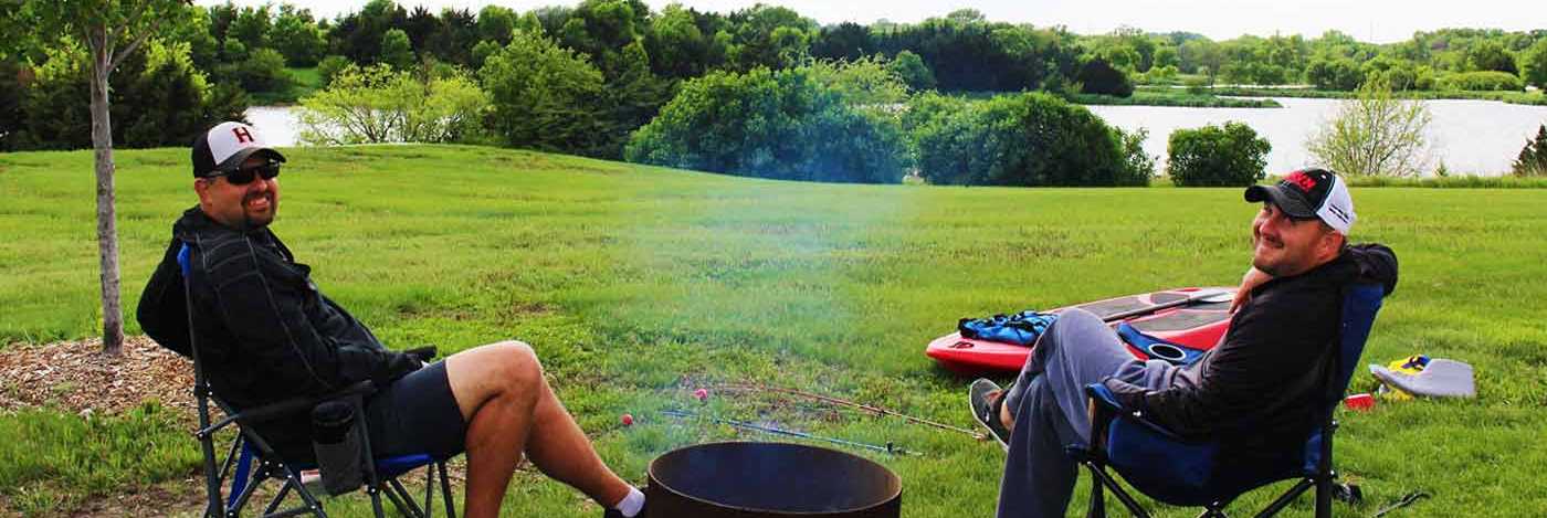smiling fishermen next to a barbeque pit