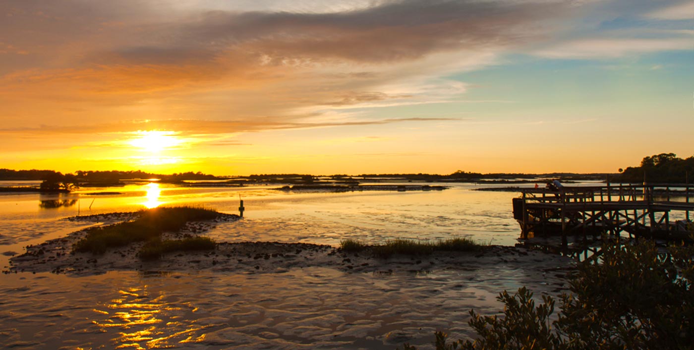 dock and sunset over lagoon in cedar key