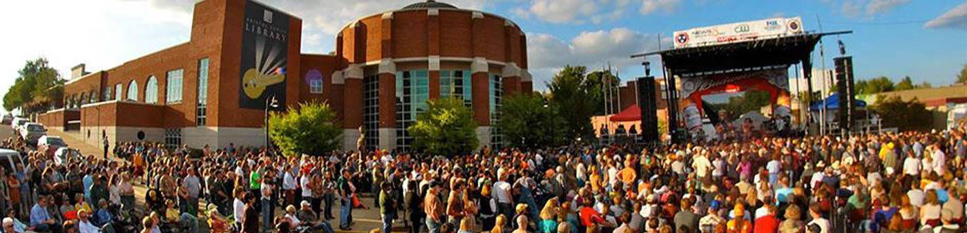 community outdoor concert with a large crowd in front of a public library