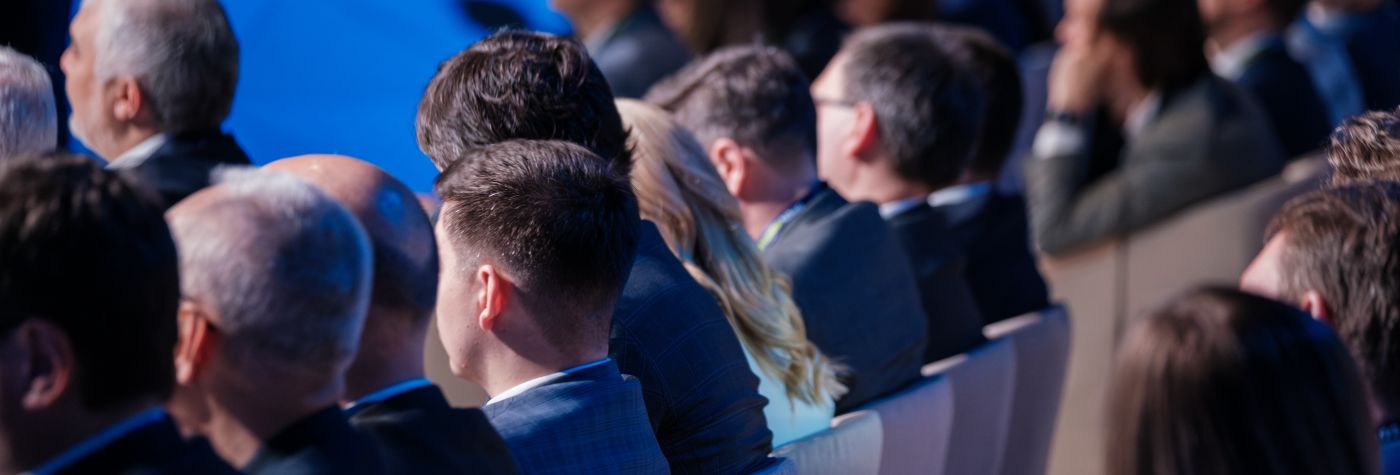professionally-dressed audience members at a business event