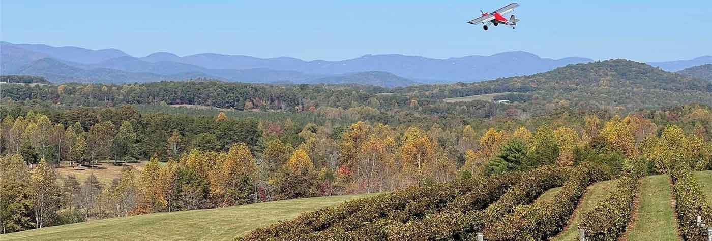Small aircraft flying over Chattooga Belle Farm Mountains in Oconee County, SC