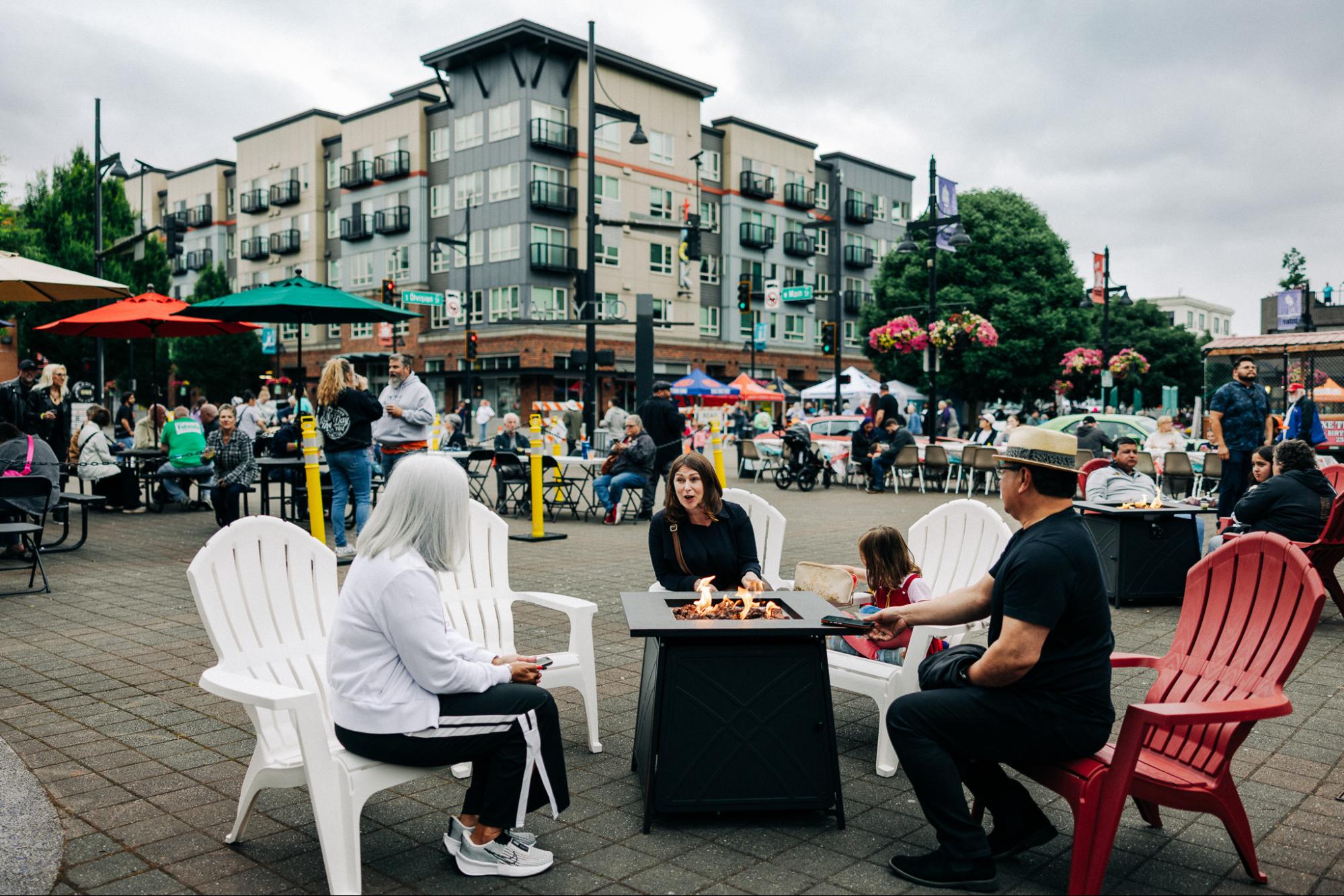 people sitting around a fire in a town center