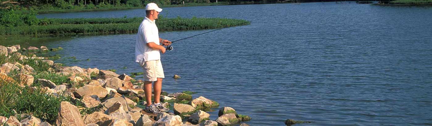 Fisherman fishing from the shore on a lake in Greenville, TX