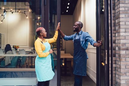 Two happy business partners engaging in a high five