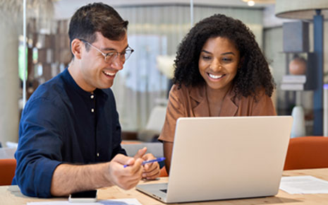 A man and a woman going over information on a computer.