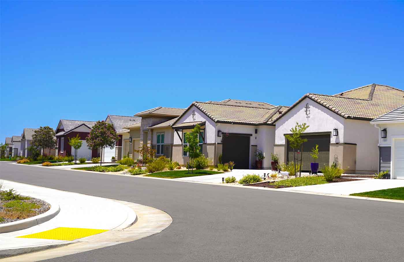 row of single family homes under a blue sky in suburban California