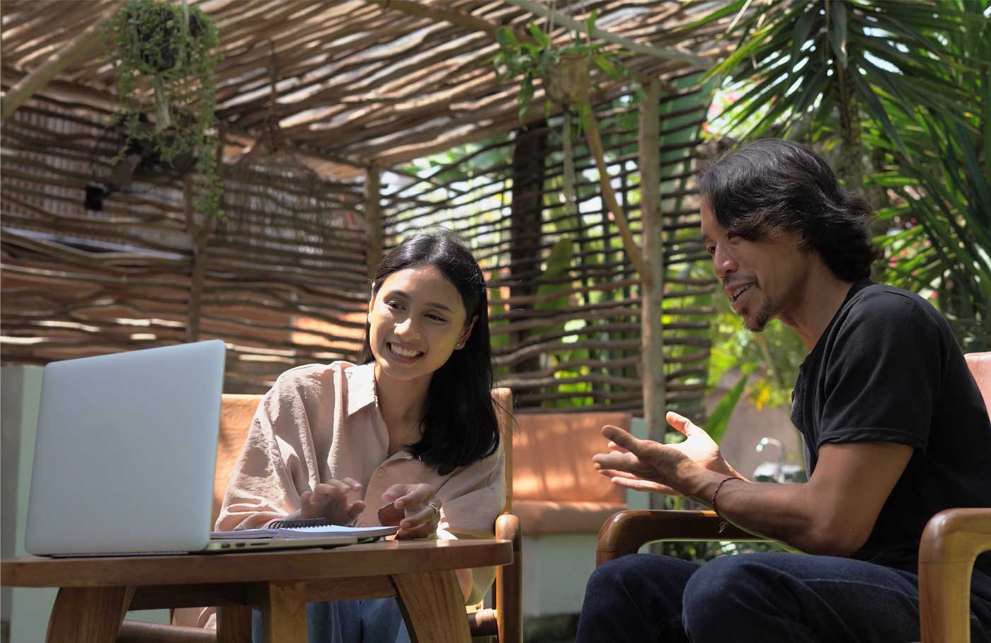 Workers having an online call outside next to palm trees