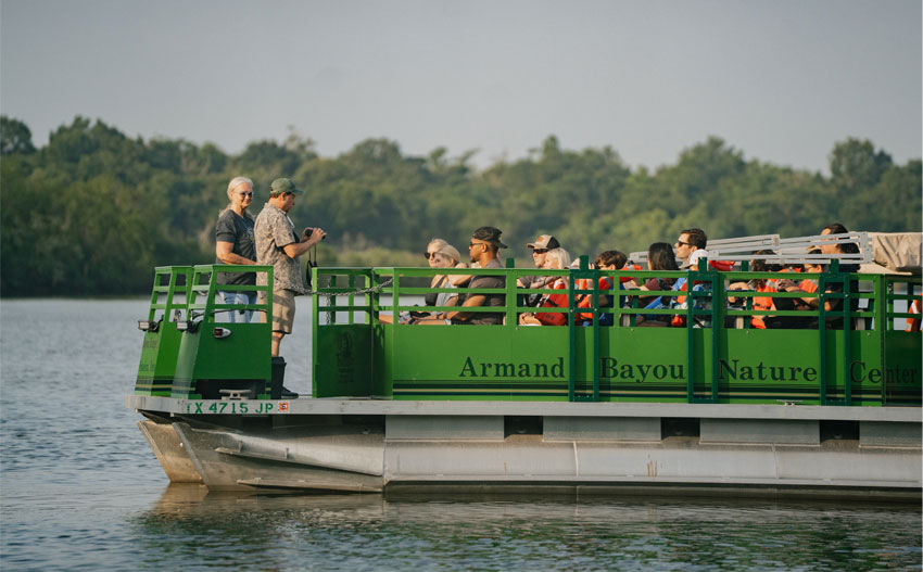 A group of people enjoying a pontoon ride at Armand Bayou Nature Center in Pasadena, TX