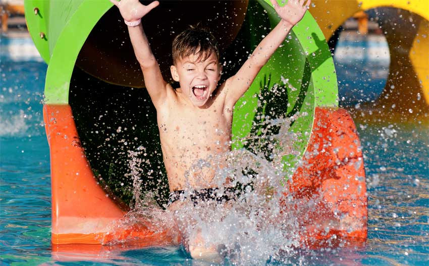 Boy exiting water slide at a waterpark