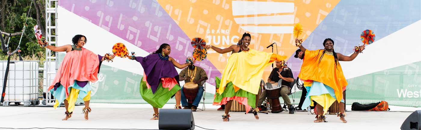 Black women dancing on stage in colorful costumes in Westfield, IN