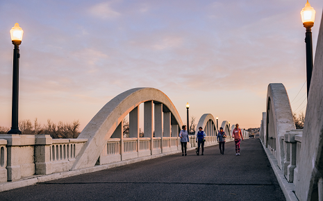 The image shows the historic Rainbow Arch Bridge in Fort Morgan, Colorado.