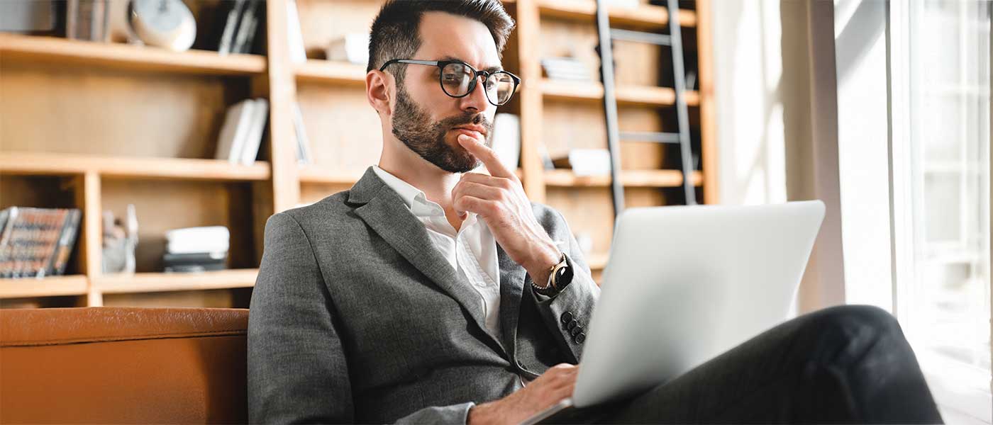 businessman in suit sitting with laptop in lap