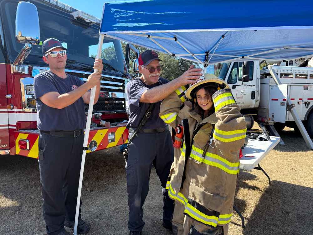 Young girl trying on a firefighter's uniform