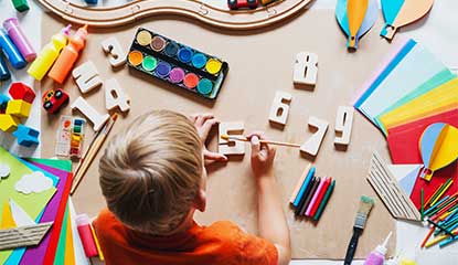 child painting wooden numbers in a daycare setting