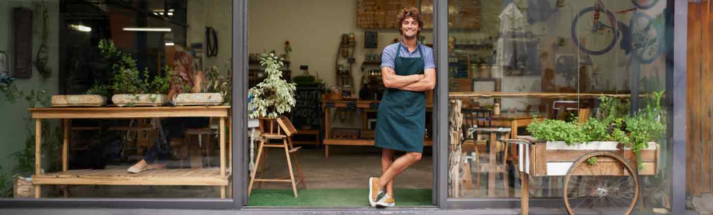 smiling coffee shop owner standing at his door
