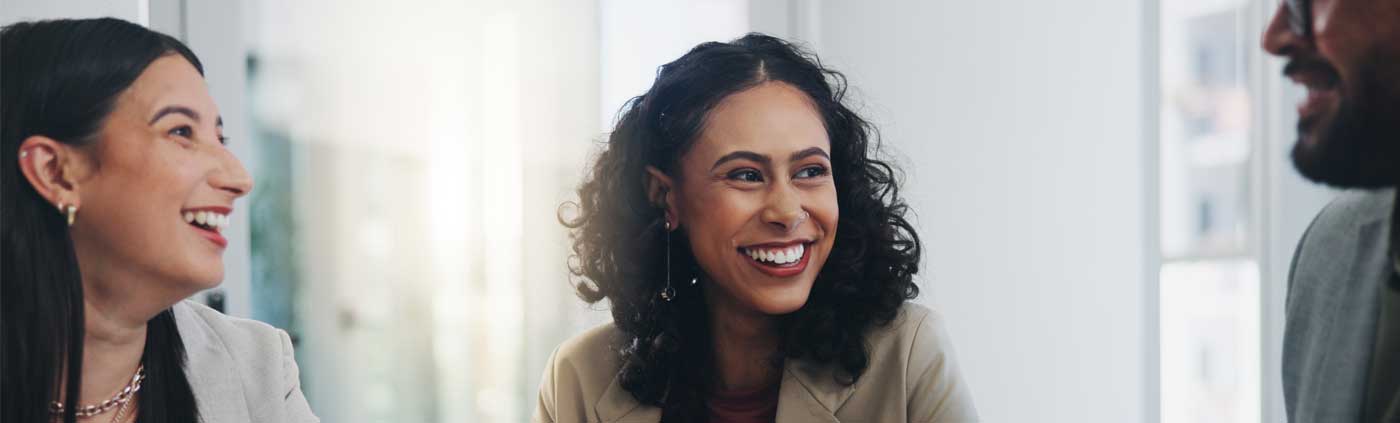Three people in a meeting smiling