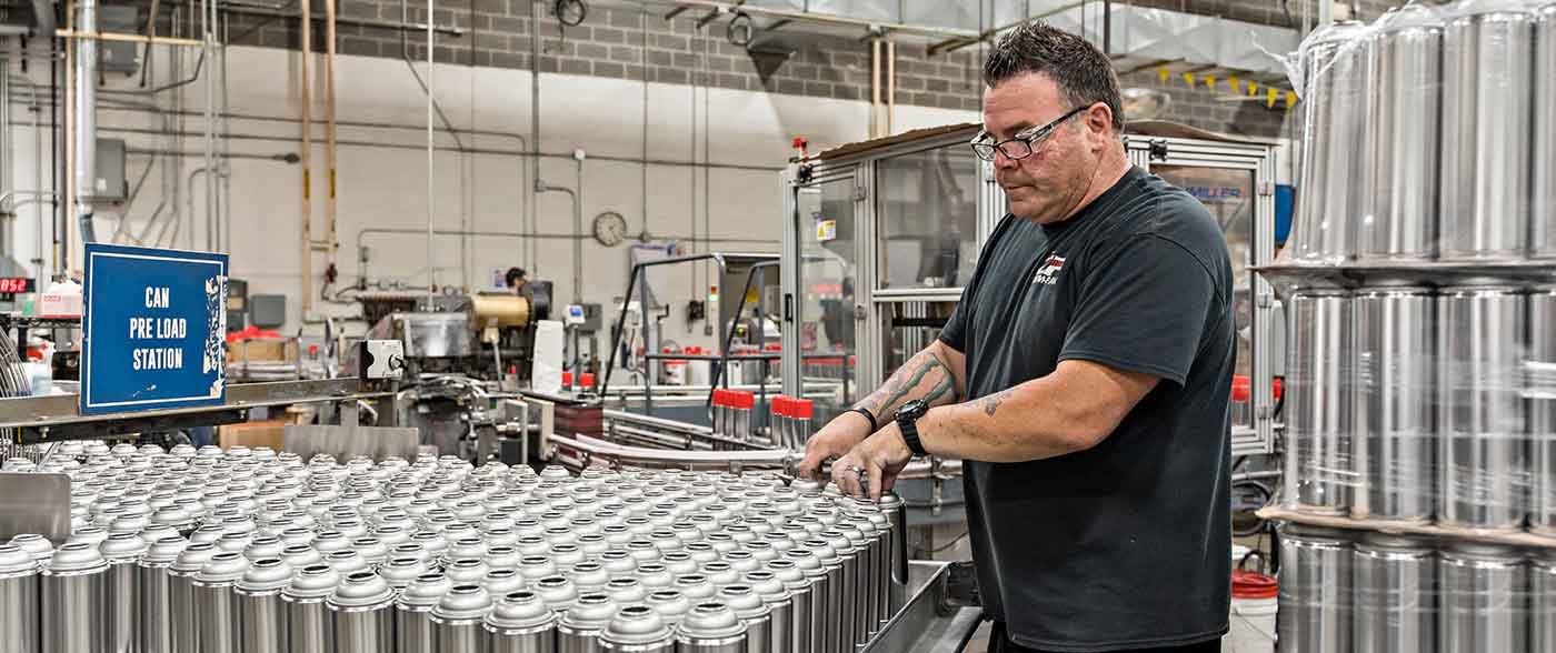 chem pak employee working with spray cans on an assembly line