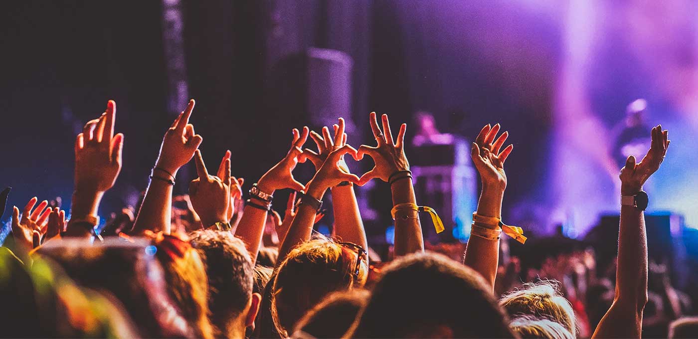 concert goers cheering and signing hearts towards the stage
