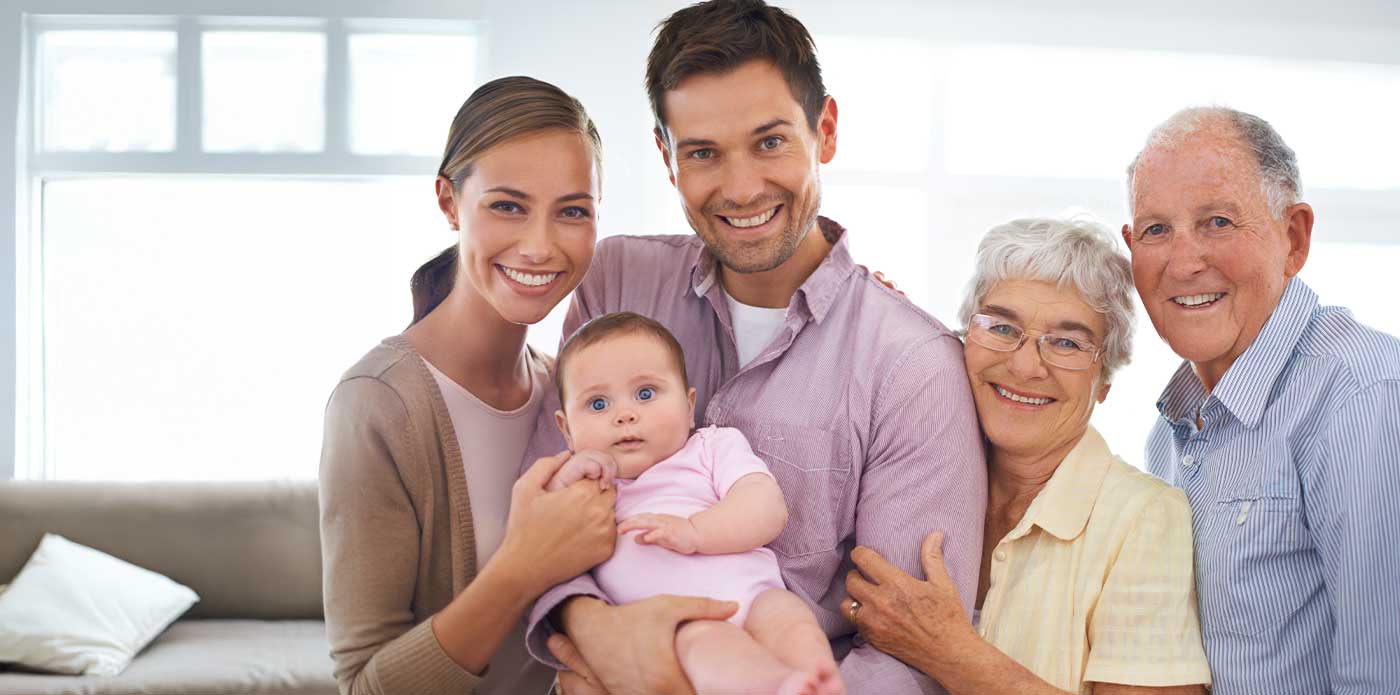 group photo of baby with smiling parents and grandparents